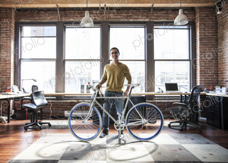 Hispanic man at his office workstation with a bicycle.