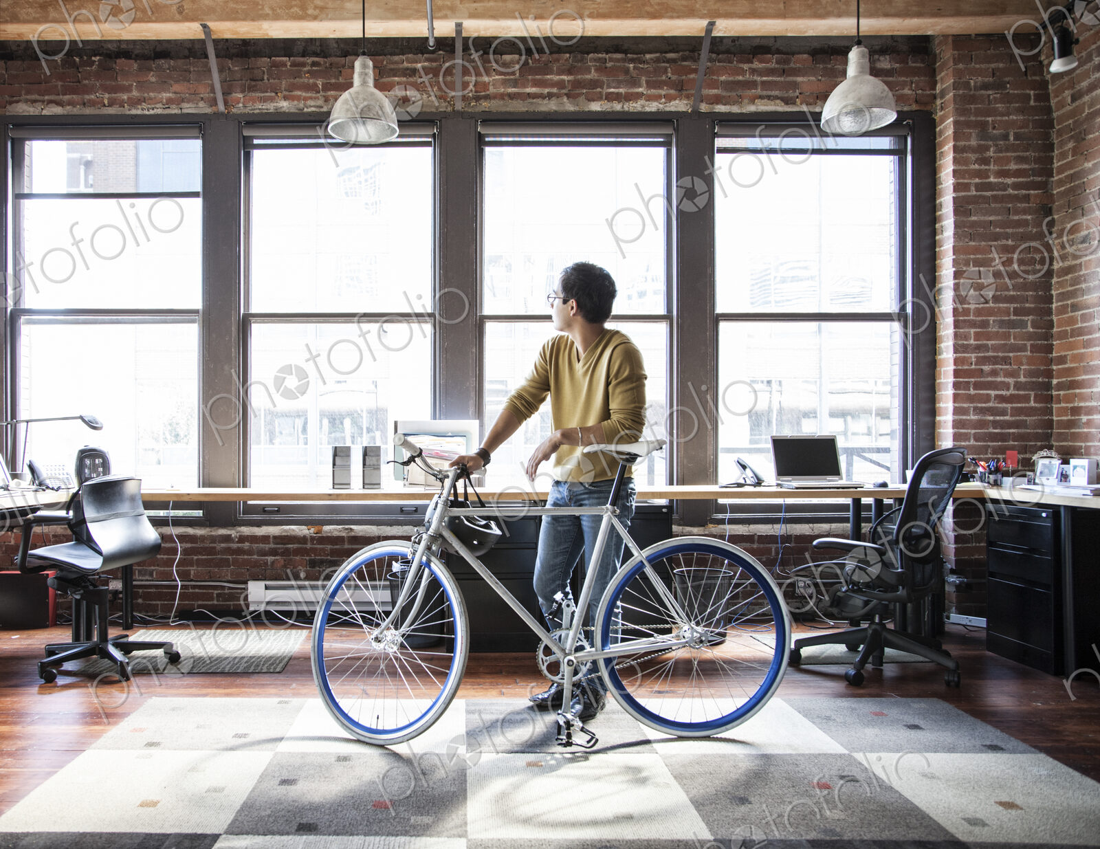 Hispanic man at his office workstation with a bicycle.