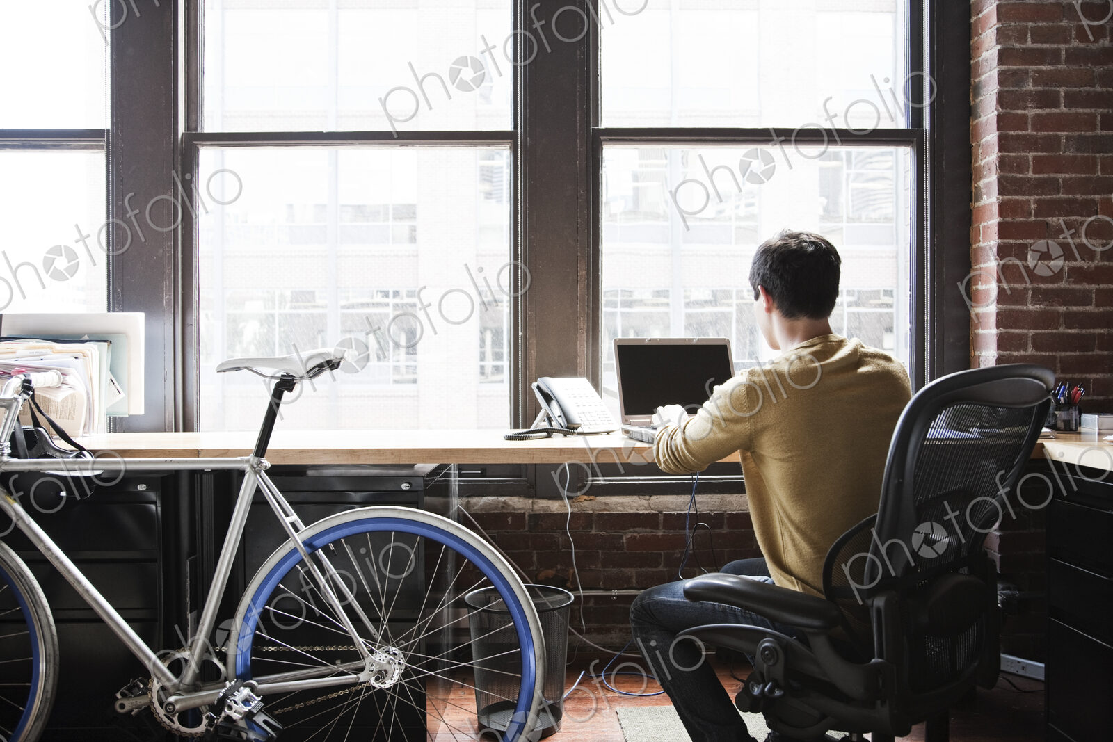 Hispanic man at his office workstation with a bicycle.