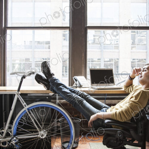 Hispanic man at his office workstation with a bicycle. Hispanic man at his office workstation with a bicycle.