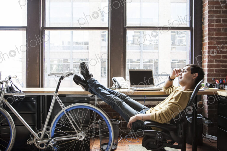 Hispanic man at his office workstation with a bicycle.