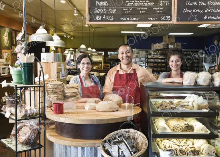 Hispanic man baker and his employees at the bakery.