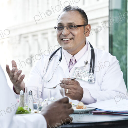 Hispanic man doctor in a lunch discussion with a colleague. Hispanic man doctor in a lunch discussion with a colleague.