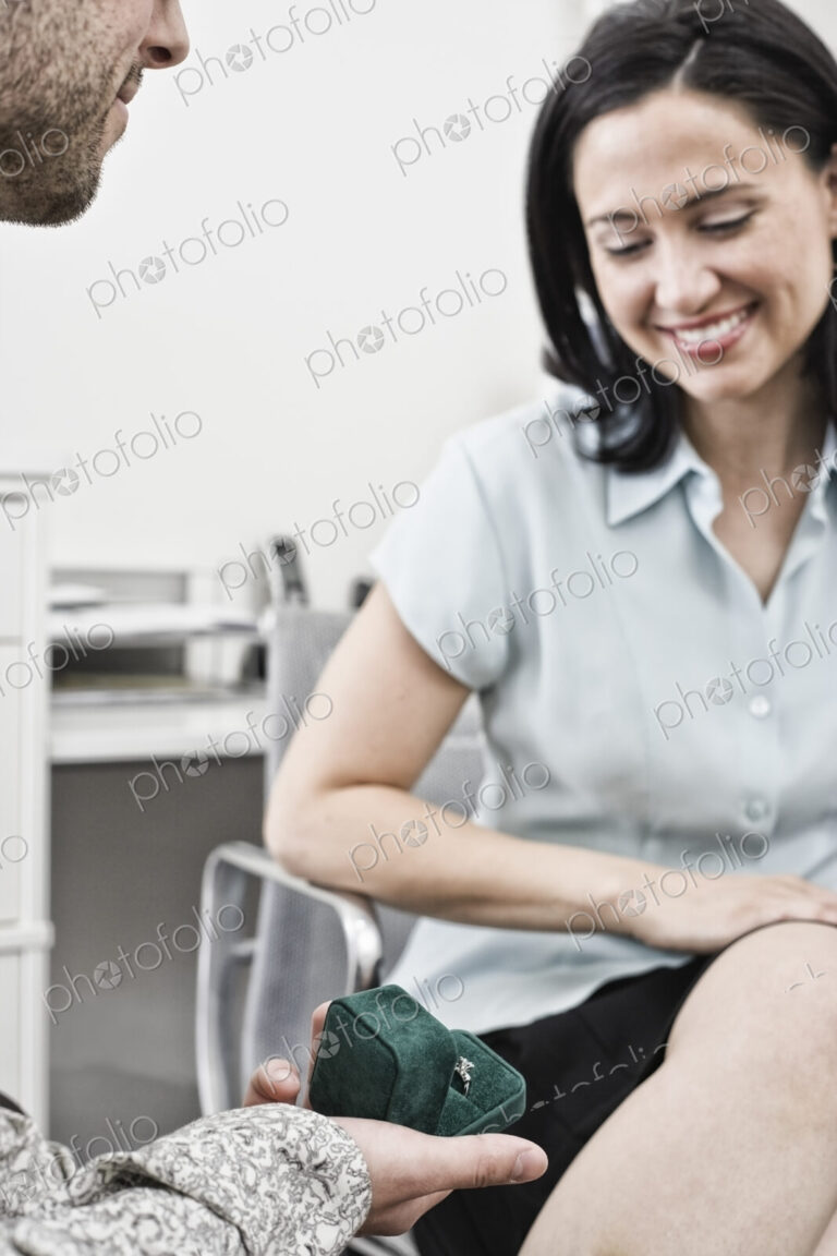Hispanic man giving a ring to a hispanic woman.