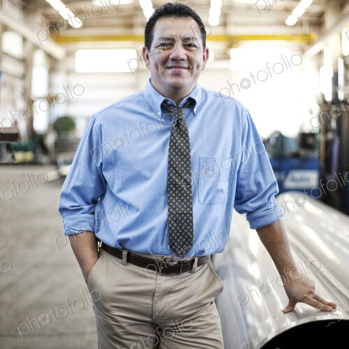 Hispanic man manager in a large sheet metal factory. Hispanic man manager in a large sheet metal factory.