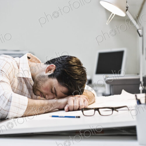 Hispanic man taking a quick nap in an architect's office. Hispanic man taking a quick nap in an architect's office.