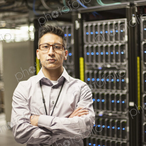 Hispanic man technician doing diagnostic tests on computer servers in a large server farm. Hispanic man technician doing diagnostic tests on computer servers in a large server farm.
