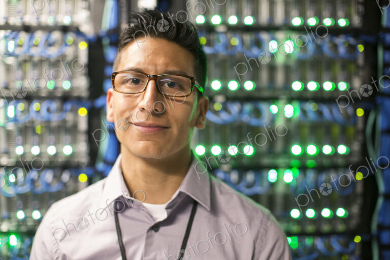 Hispanic man technician in a large computer server farm.