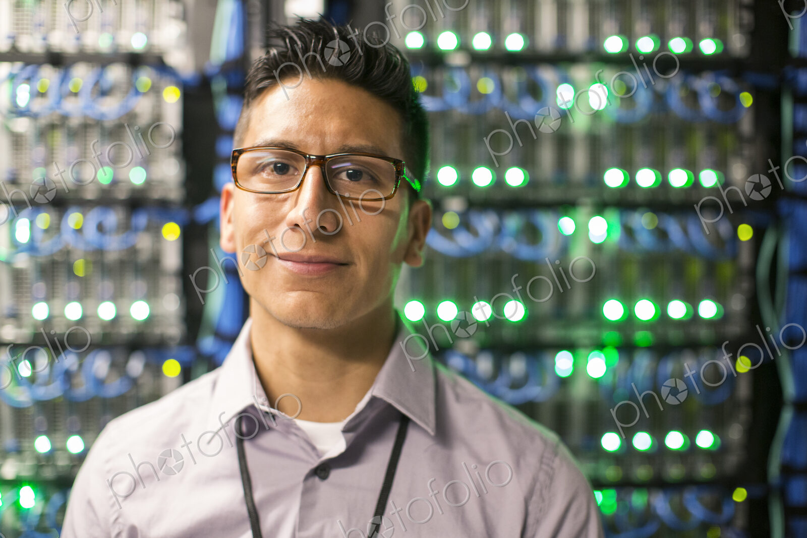 Hispanic man technician in a large computer server farm.