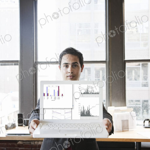Hispanic man with his laptop at his office workstation. Hispanic man with his laptop at his office workstation.