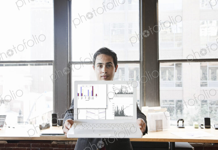 Hispanic man with his laptop at his office workstation.