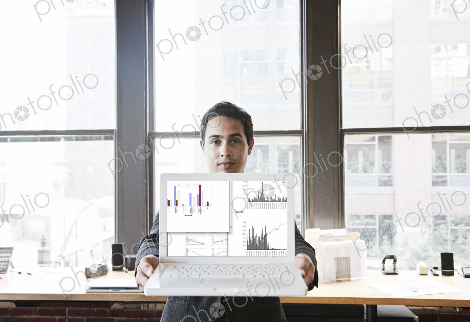 Hispanic man with his laptop at his office workstation.