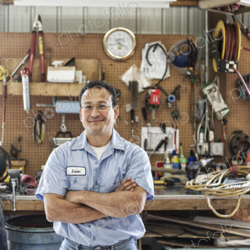 Hispanic man worker in the shop area of a landscape company.