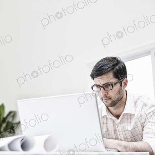 Hispanic man working in an architect's office. Hispanic man working in an architect's office.