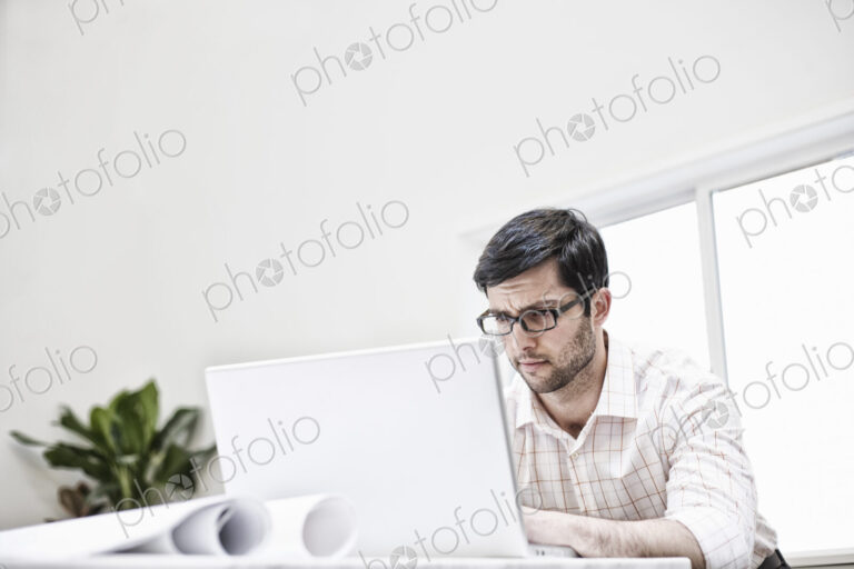 Hispanic man working in an architect's office.