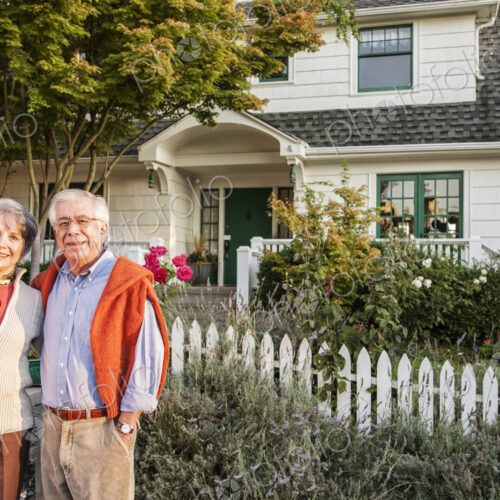 Hispanic senior couple in front of their remodeled older style home. Hispanic senior couple in front of their remodeled older style home.