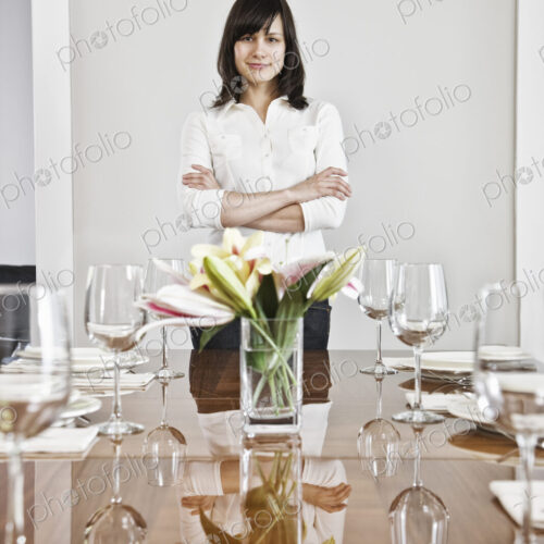 Hispanic woman alone at the head of her dinning room table in a new home. Hispanic woman alone at the head of her dinning room table in a new home.