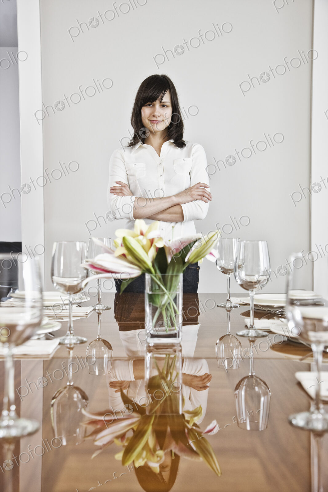 Hispanic woman alone at the head of her dinning room table in a new home.
