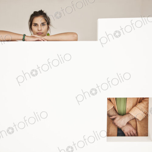 Hispanic woman and man viewed from two viewpoints in a low wall with a square opening. Hispanic woman and man viewed from two viewpoints in a low wall with a square opening.