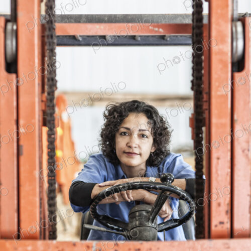 Hispanic woman employee using a forklift in a landscape company. Hispanic woman employee using a forklift in a landscape company.