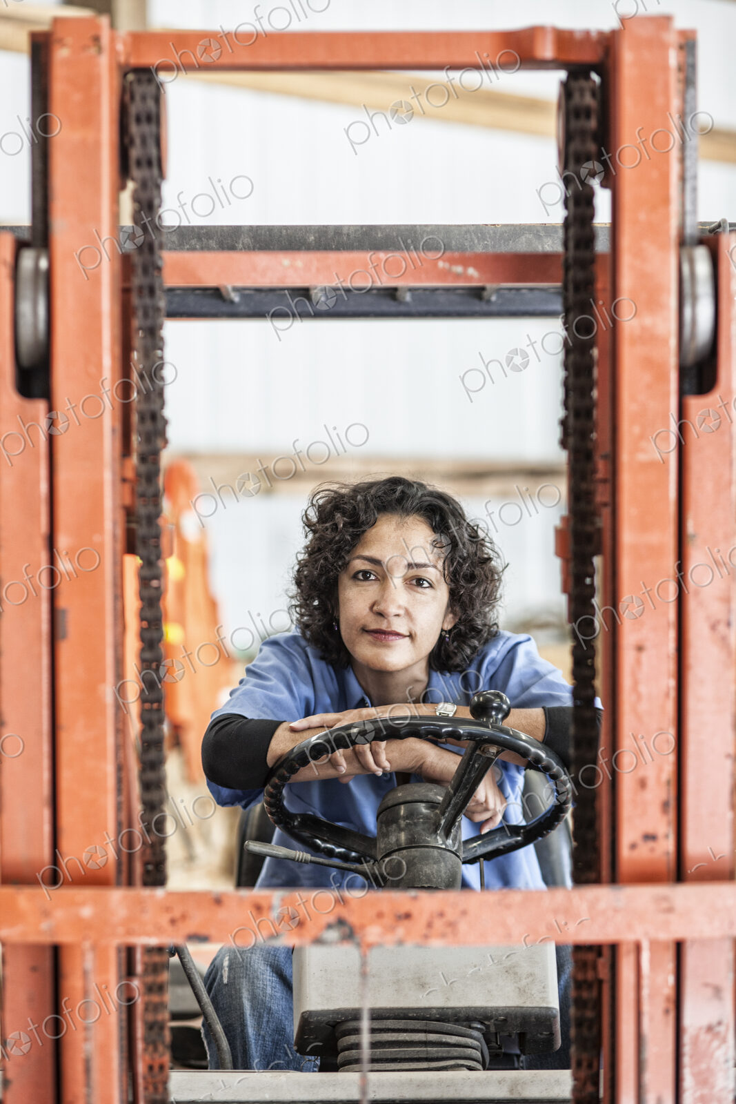 Hispanic woman employee using a forklift in a landscape company.