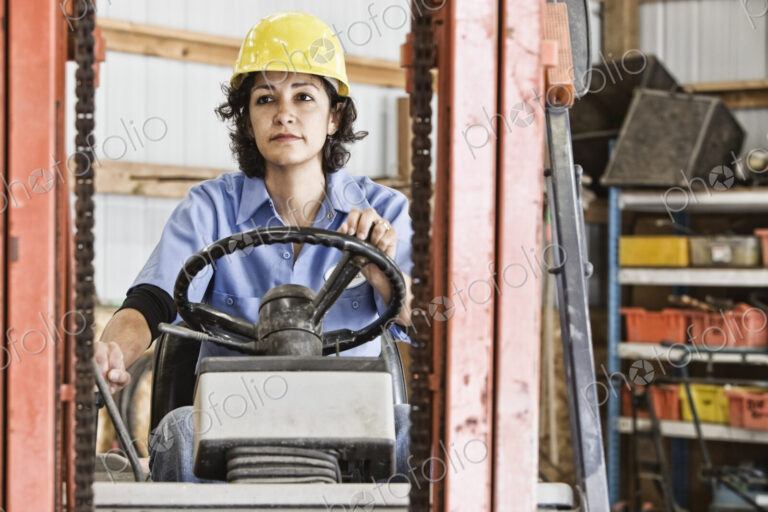 Hispanic woman employee using a forklift in a landscape company.