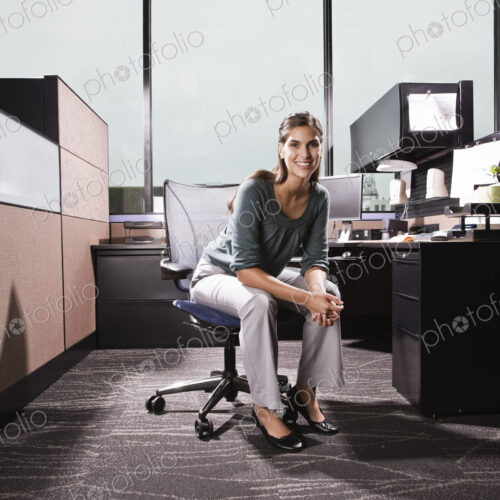 Hispanic woman in an office cubicle. Hispanic woman in an office cubicle.