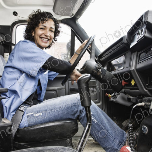Hispanic woman truck driver and company delivery truck. Hispanic woman truck driver and company delivery truck.