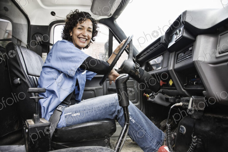 Hispanic woman truck driver and company delivery truck.