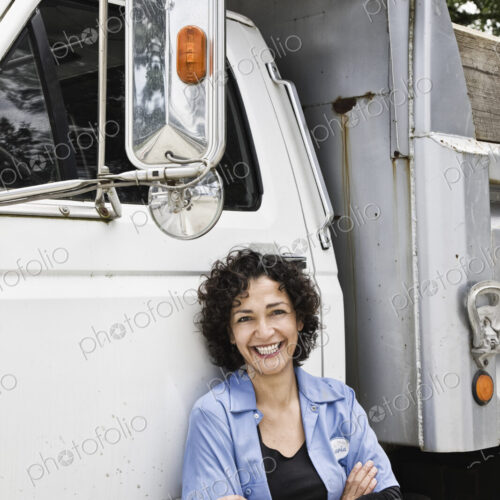 Hispanic woman truck driver and company delivery truck. Hispanic woman truck driver and company delivery truck.