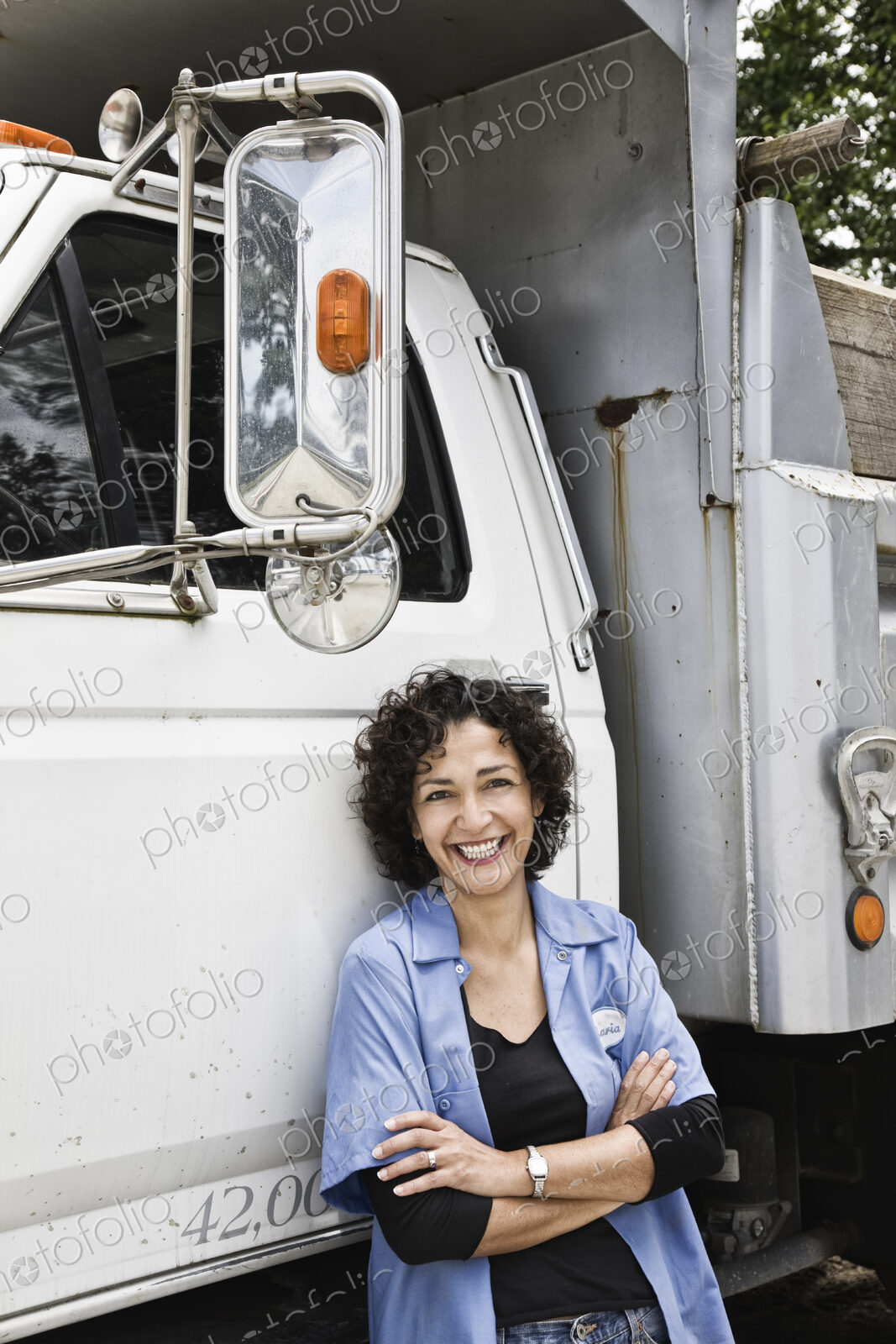 Hispanic woman truck driver and company delivery truck.