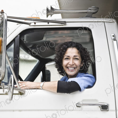 Hispanic woman truck driver and company delivery truck. Hispanic woman truck driver and company delivery truck.