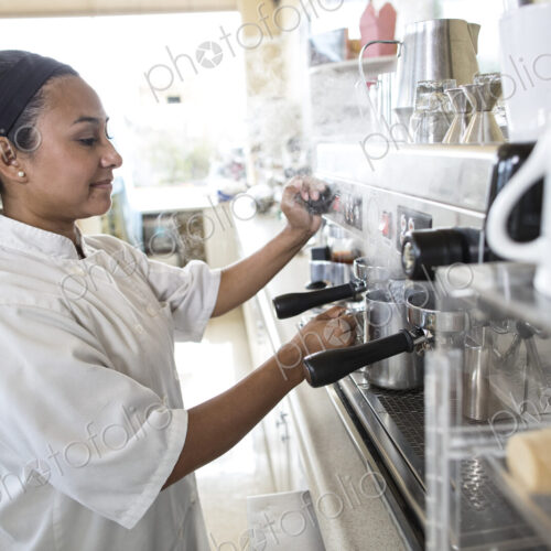 Hispanic woman working an espresso machine in a candy shop. Hispanic woman working an espresso machine in a candy shop.