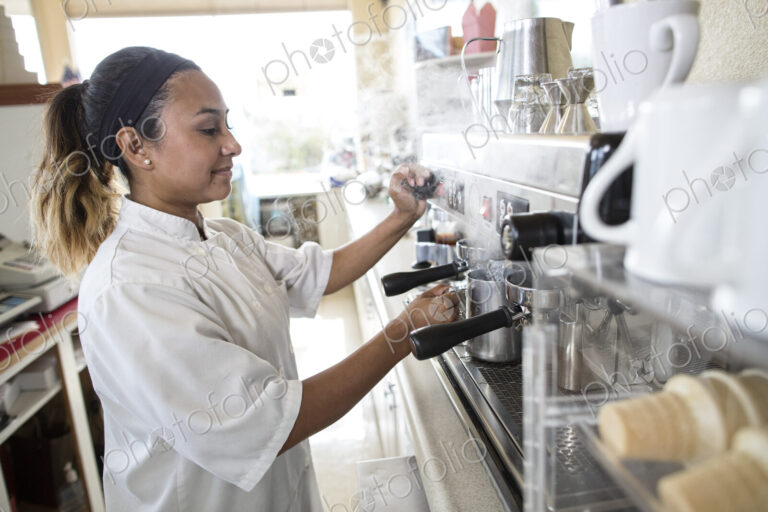 Hispanic woman working an espresso machine in a candy shop.