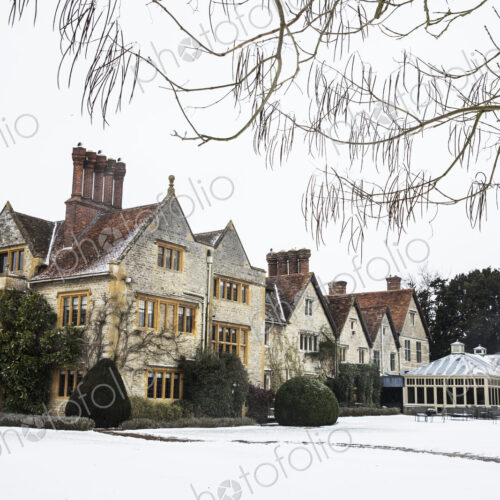 Historic 17th century manor house with tall chimneys, a hotel with snow covered…
