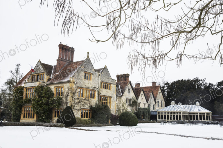 Historic 17th century manor house with tall chimneys, a hotel with snow covered…