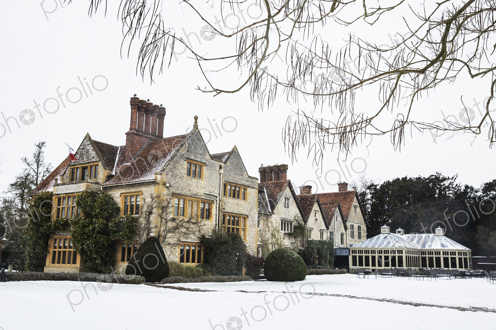 Historic 17th century manor house with tall chimneys, a hotel with snow covered…