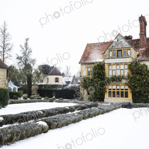 Historic 17th century manor house with tall chimneys, a hotel with snow covered…