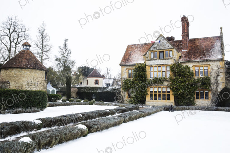 Historic 17th century manor house with tall chimneys, a hotel with snow covered…