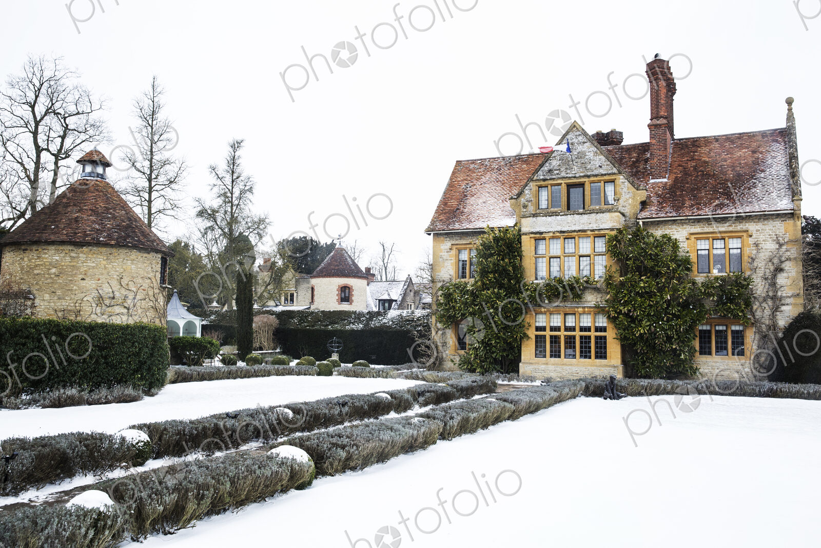 Historic 17th century manor house with tall chimneys, a hotel with snow covered…