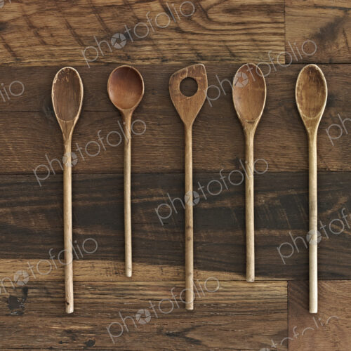 Home cooking. A wooden table with a varied wood grain and colour. Five wooden spoons… Home cooking. A wooden table with a varied wood grain and colour. Five wooden spoons…