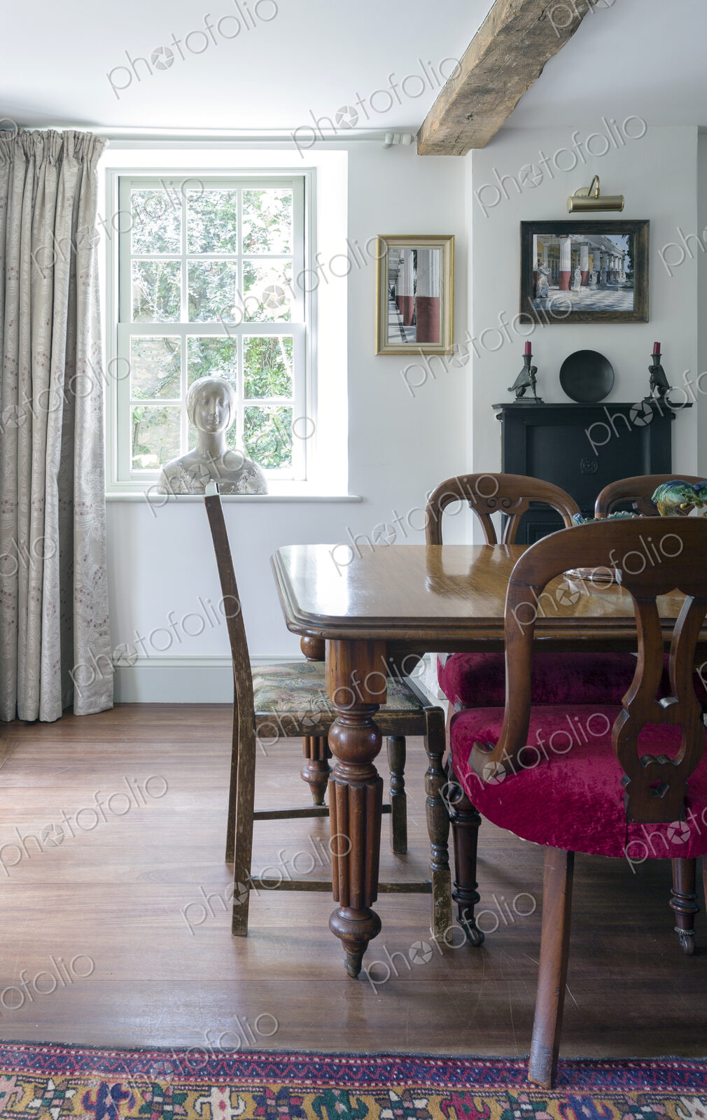 Home interior, antique bust on window near dining table