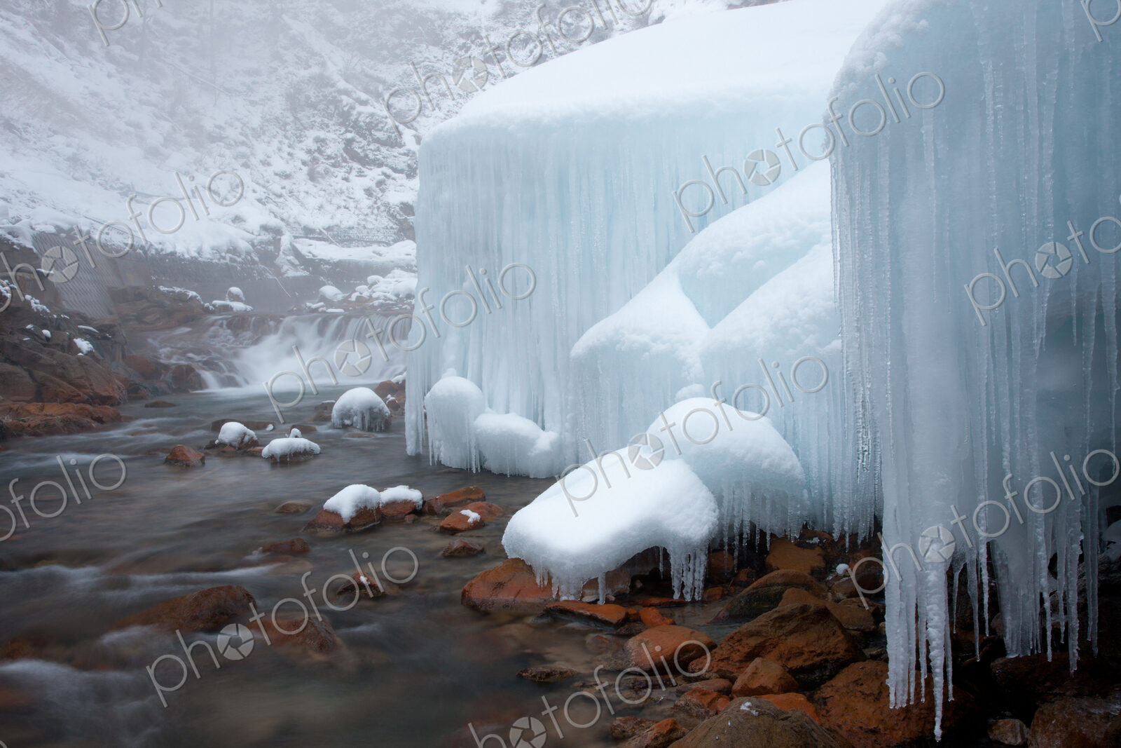 Honshu island, Nagano, Japan. Icicles and blocks of frozen snow by a stream.