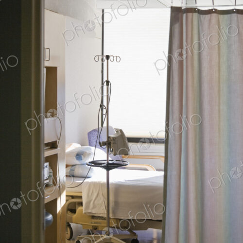 Hospital room with bed and privacy curtain.