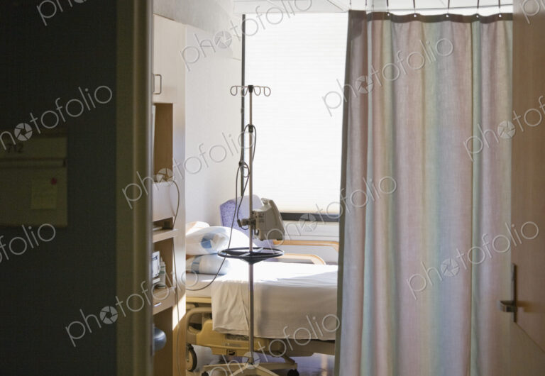 Hospital room with bed and privacy curtain.