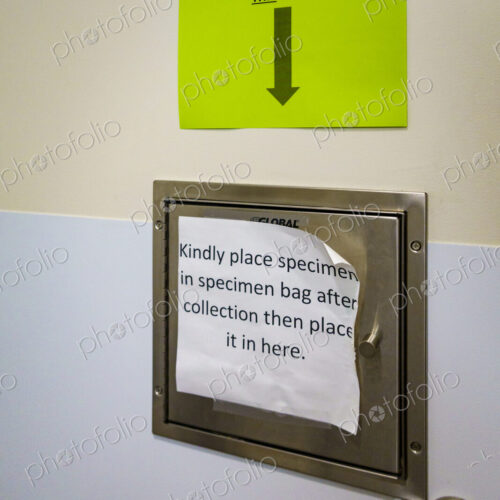 Hospital specimen deposit drawer, an instruction sign and arrow.