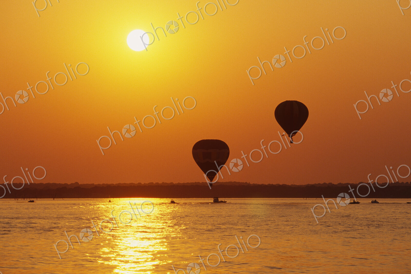 Hot Air Balloons Over Water at Sunset