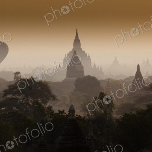 Hot-air balloon floats through the hazy skies of Bagan, Myanmar Hot-air balloon floats through the hazy skies of Bagan, Myanmar