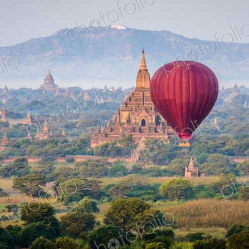 Hot air balloon flying over towers