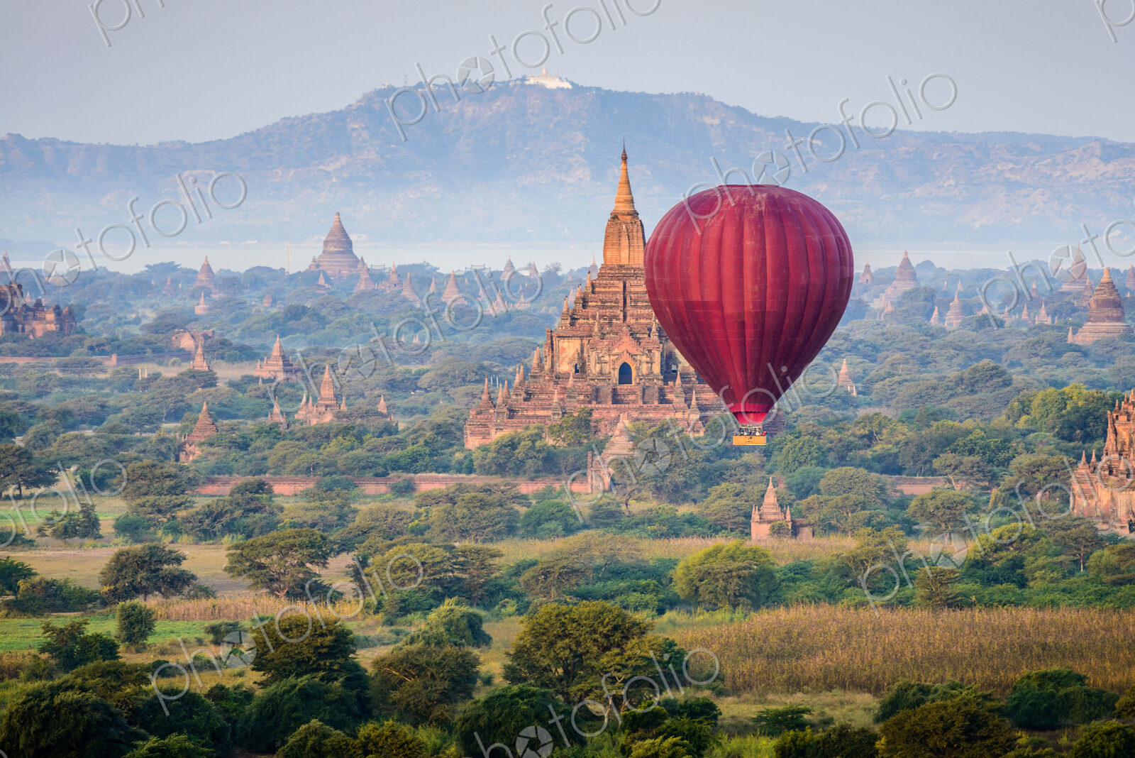 Hot air balloon flying over towers